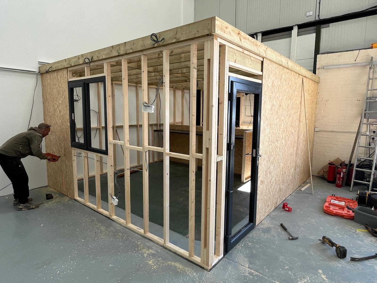 Timber frame of the new reception and office going up inside the empty unit