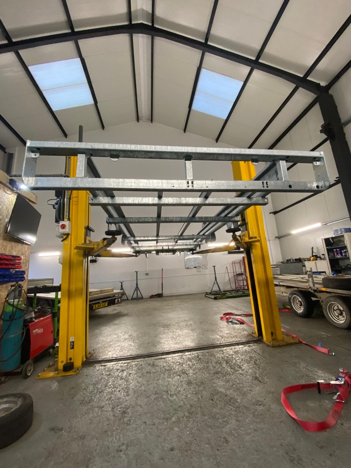 Galvanised trailer chassis raised on the two-post lift