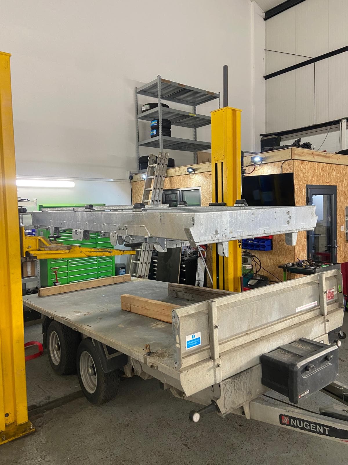 Trailer on the lift with tyres and parts stock behind