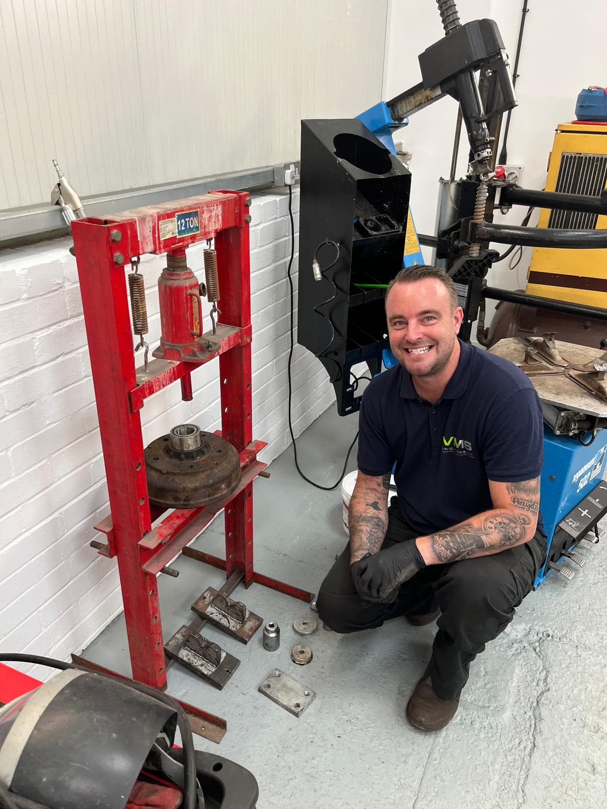 Craig in the workshop beside the hydraulic press with a trailer brake drum